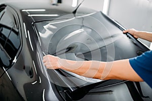 Male specialist with car tinting film in hands