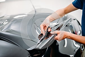 Male specialist with scissors, car tinting film