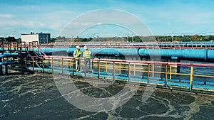 Male specialists walking across a sewage cleaning facility