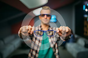 Male spectator shows 3d glasses in cinema hall