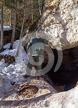 Male speleologist at the entrance to the cave