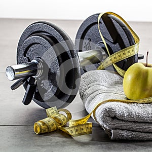 Male sport lifestyle with weights and measuring tape at gym
