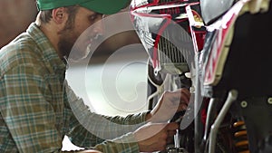 Male sportsman repairing his enduro motorcycle