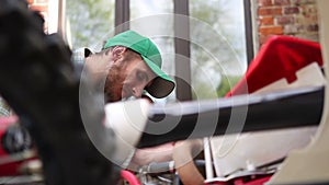 Male sportsman repairing his enduro motorcycle