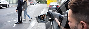 Male Spy Taking Photograph Of A Couple Walking On Street