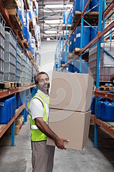 Male staff carrying cardboard boxes in warehouse
