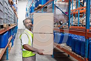 Male staff carrying cardboard boxes in warehouse