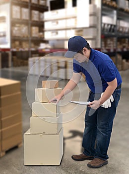 Male staff and parcel boxes checking stock and Blurred the background of the warehouse