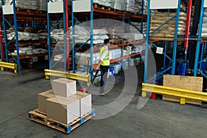 Male staff using pallet jack in warehouse