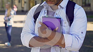 Male standing alone, having unreturned feelings for pretty girl, shy student