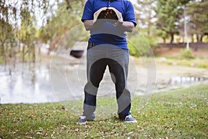 Male standing in a grassy field while reading the bible with a blurred background