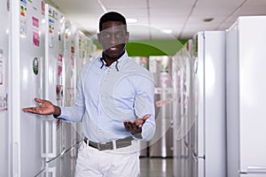 Male standing near fridges in store of kitchen appliances