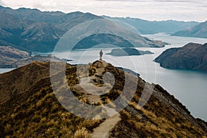 Male standing on a top of the mountain range with a sea in the background, Roys Peak Glendhu