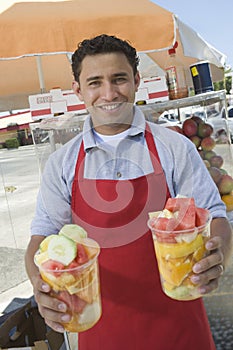 Male Street Vendor Holding Fresh Fruit Salads