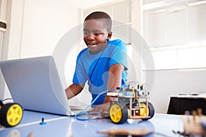 Male Student Building And Programing Robot Vehicle In After School Computer Coding Class photo