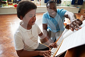 Male Student Enjoying Piano Lesson With Teacher