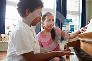 Male Student Enjoying Piano Lesson With Teacher