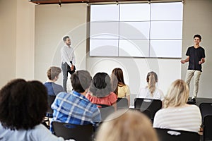 Male Student Giving Presentation To High School Class In Front Of Screen