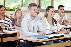 Male student listening a lecture in classroom