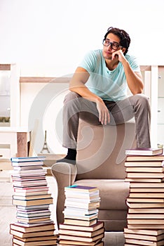 Male student with many books at home