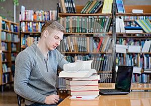 Male student reading book in library