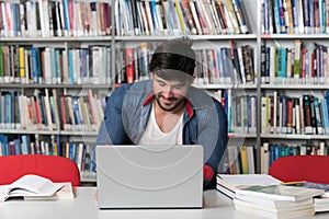 Male Student Typing on Laptop in the University Library