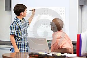 Male Student Writing Answer On Whiteboard