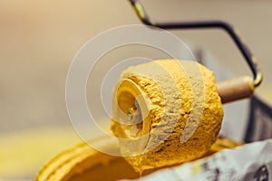 Male students use small paint rollers to paint yellow lines on the cement floor