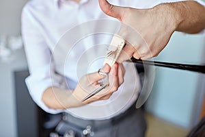 Male stylist hands cutting hair tips at salon