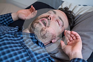 Male suffering sleep apnea lying in the bed