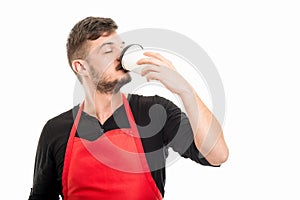 Male supermarket employer drinking takeaway coffee
