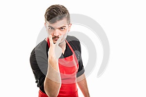 Male supermarket employer showing watching you gesture