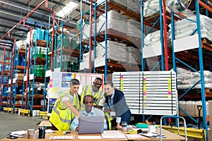 Male supervisor with his coworkers discussing over laptop at desk