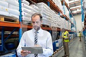 Male supervisor working on digital tablet in warehouse