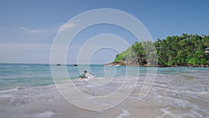 Male surfer in long sleeve rash guard paddling on surfboard. Man in rashguard swimwear swims to lineup lying on