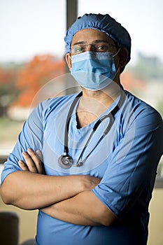 male surgeon in face mask with arms