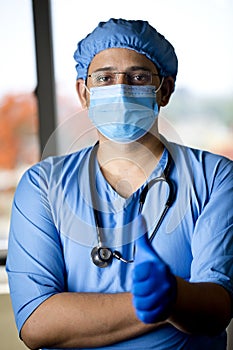 male surgeon in face mask with arms