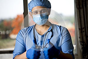 male surgeon in face mask with arms