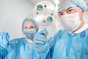 Male surgeon holding syringe isolated on a white background. Focus on syringe