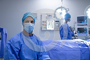 Male surgeon sitting with surgical mask in operation theater
