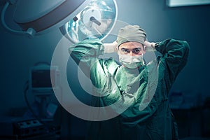 Male surgeon tying face mask at operating room