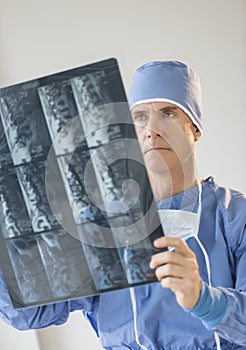 Male Surgeon In Uniform Looking At X-Ray