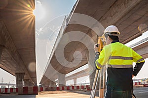 A male surveyor engineers worker use radio communication and making measuring with theodolite on road works. Survey engineer at