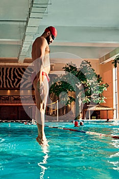 A male swimmer dives into the pool with his head into the water, the start of the swim in the pool.