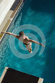 Male Swimmer Jumping From Springboard photo