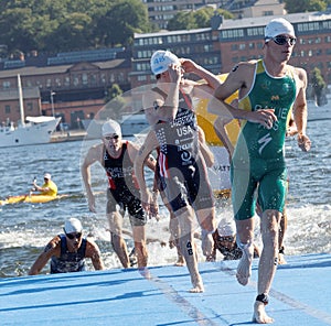Male swimmers climbing up from the water