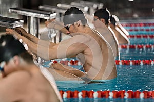 Male swimmers holding their starting blocks