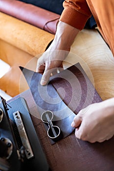 Male tanner working with handpress device machine cutting pattern on stuff material leather workshop