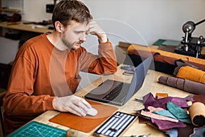 Male tanner working use laptop chatting surfing internet promotion advertisement of leatherwork
