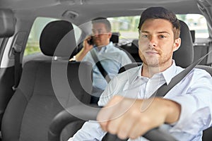 Male taxi driver driving car with passenger photo